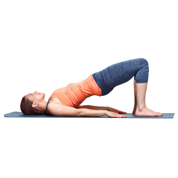 Eine Frau macht auf einer Matte die Yoga-Übung Brücke.