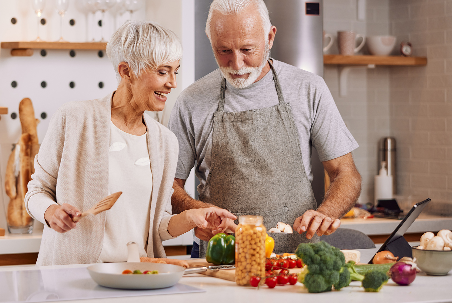 Ein Mann und eine Frau kochen in der Küche mit viel Gemüse.